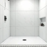 Dalle PVC murale blanche installée dans une douche à l'italienne avec finition effet pierre et niche encastrée