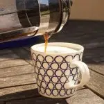 white and black ceramic mug on brown wooden table