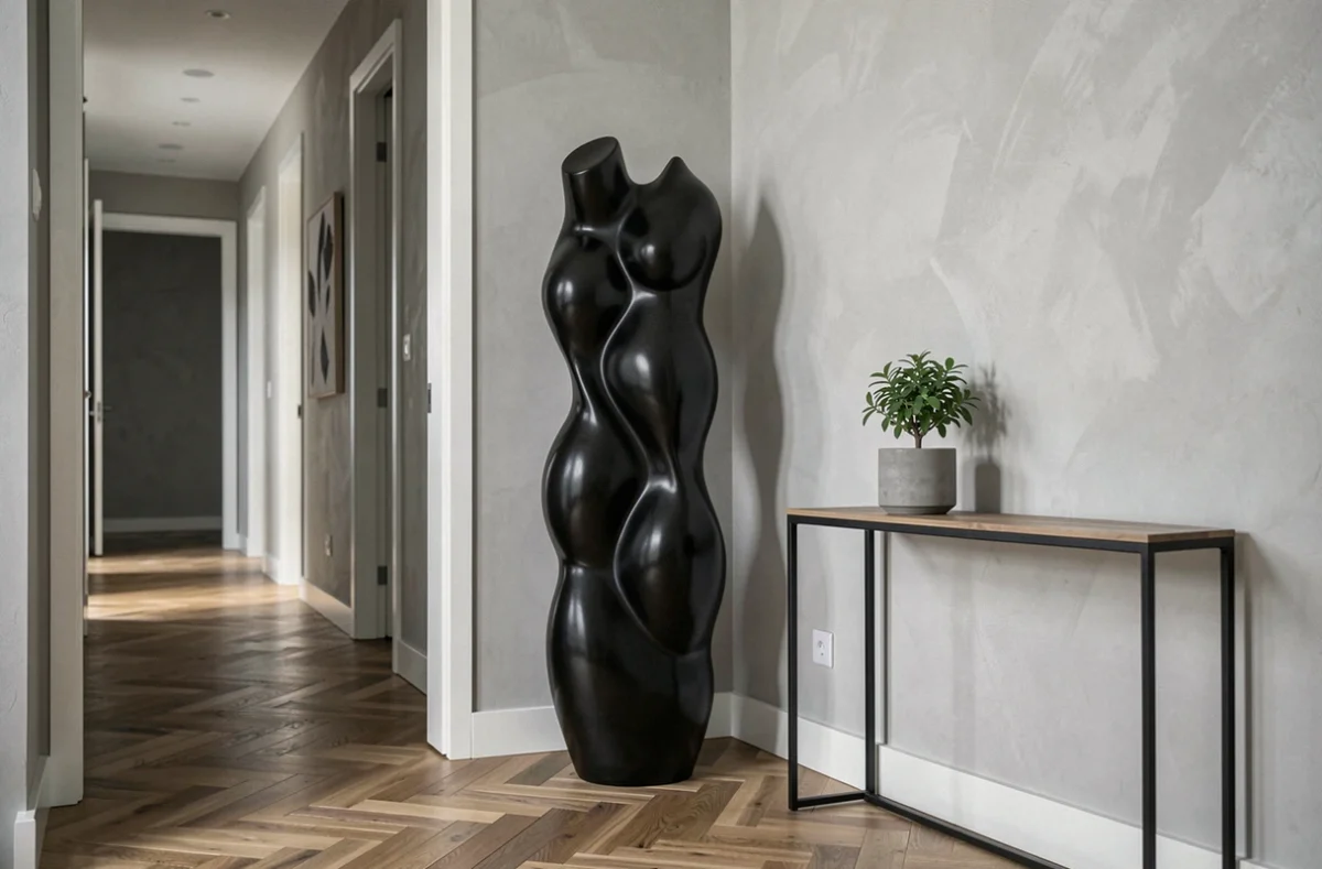 Statue céramique noire grand format dans une entrée contemporaine avec parquet en chevrons, décoration épurée